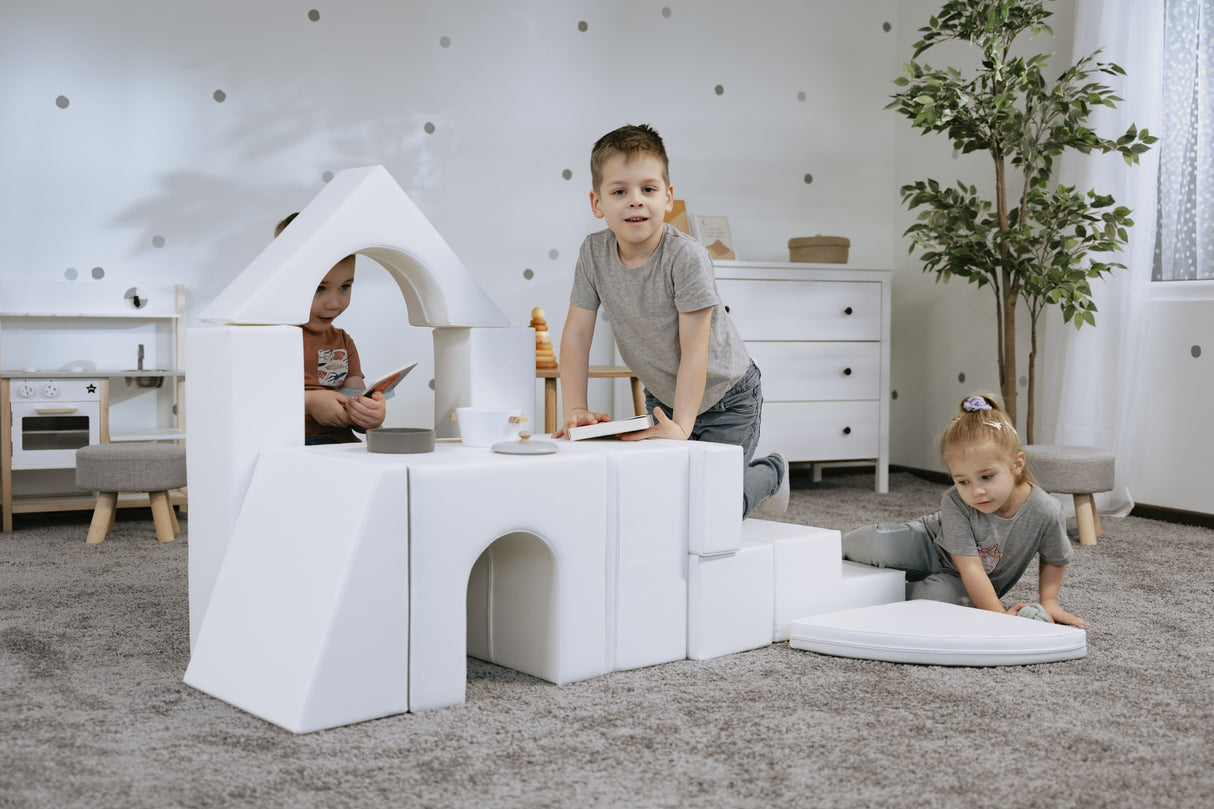 Kinder spielen mit weißen Bausteinen in einem modernen Raum