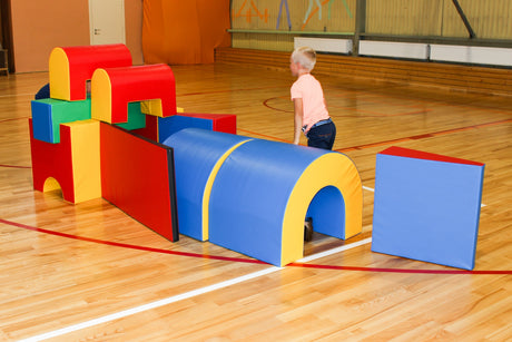Bunte Schaumstoffbausteine in einer Turnhalle, Kind spielt damit