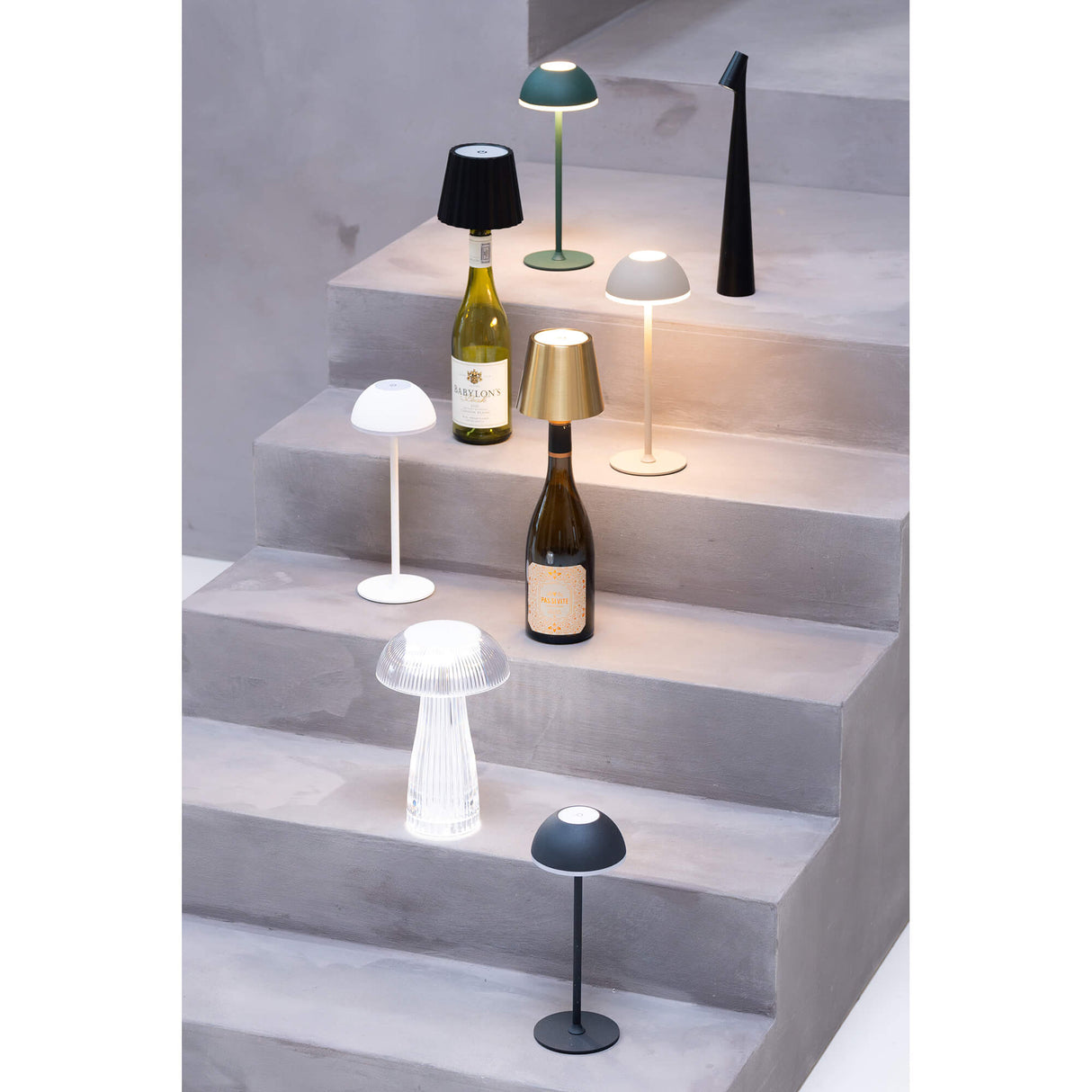 Mehrere Jens Living LED Tischlampen stehen auf einer Treppe und leuchten