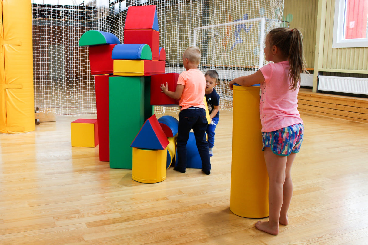 Kinder spielen mit bunten Bauklötzen in einem Innenraum