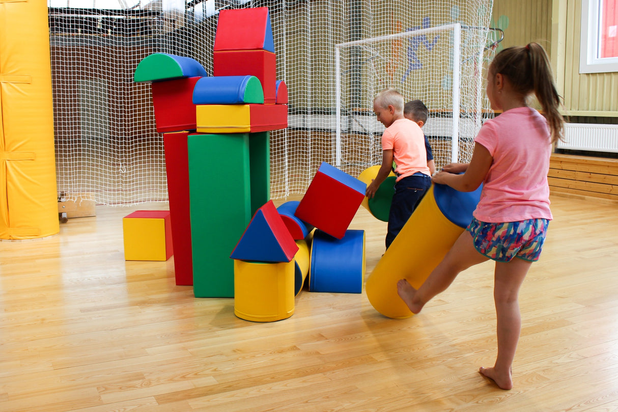 Kinder spielen mit bunten, geometrischen Bauklötzen in einem Raum