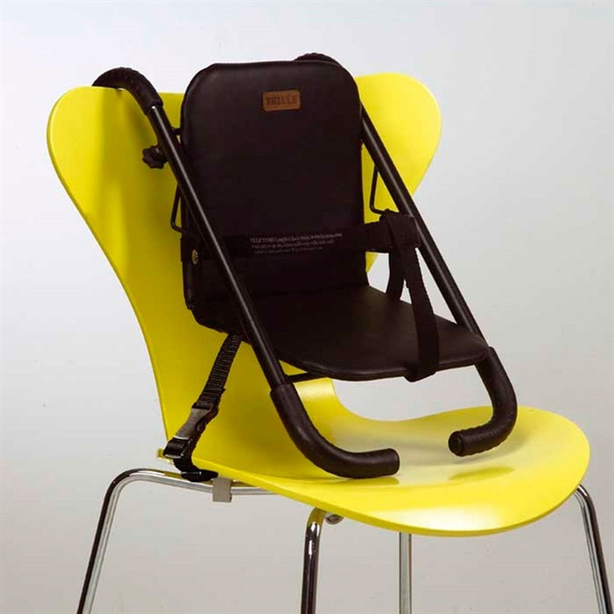 Tragbarer BabyTrold Booster-Sitz in Schwarz, aufgeklappt am Stuhl montiert mit Gurt fixiert