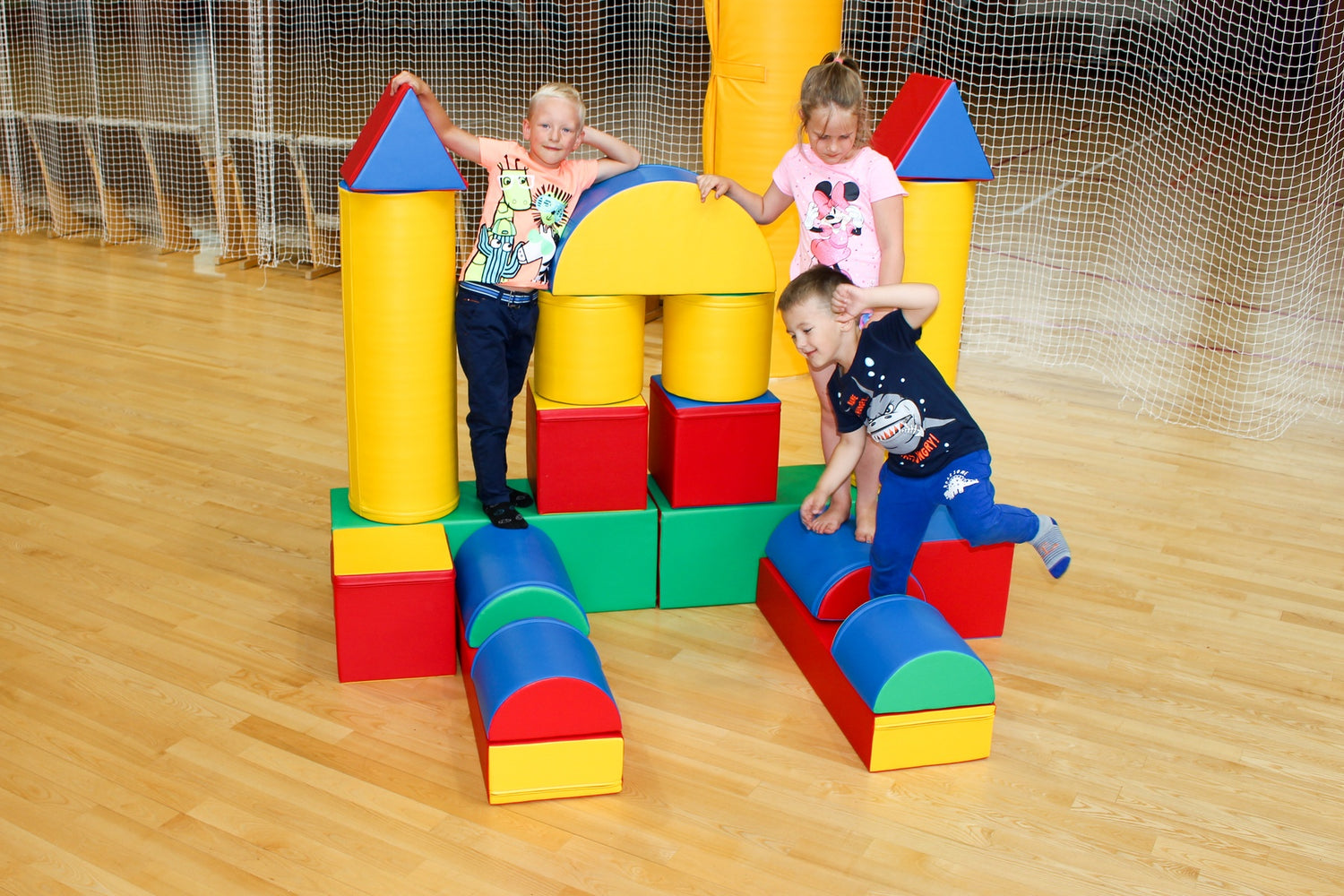Kinder spielen mit bunten Bauklötzen in einer Sporthalle