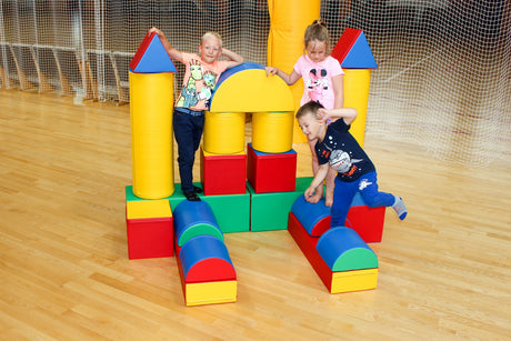 Kinder spielen mit bunten Bauklötzen in einer Sporthalle