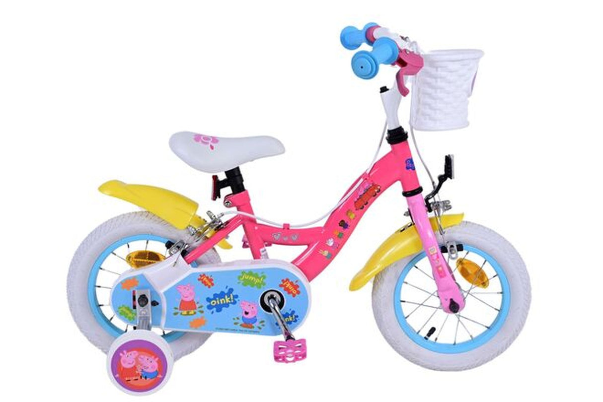 Rosa Kinderfahrrad mit Korb, weißen Reifen und bunten Aufklebern