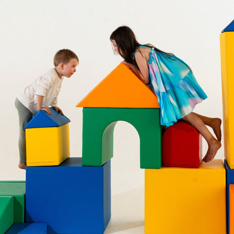 Kinder spielen mit bunten, weichen Bauklötzen in verschiedenen Formen