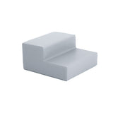 Graue, gepolsterte Sitzgelegenheit mit abgerundeten Kanten und niedriger Rückenlehne