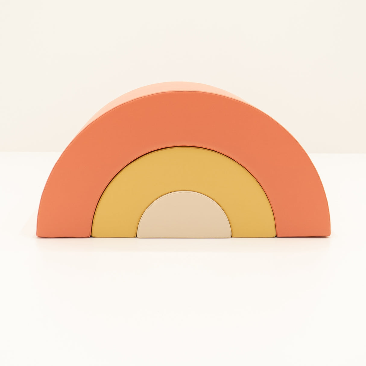 Bunte Regenbogen-Spielzeugblöcke in orange, gelb und beige angeordnet