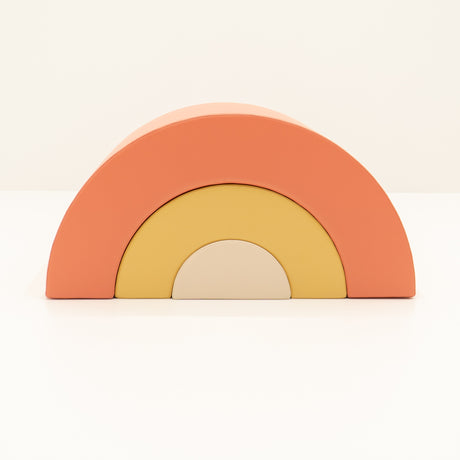 Bunte Regenbogen-Spielzeugblöcke in orange, gelb und beige angeordnet