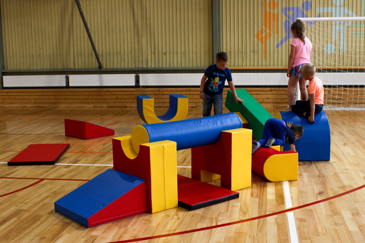 Bunte Schaumstoffbausteine in einer Sporthalle, Kinder spielen damit