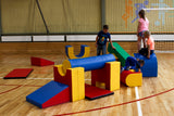 Bunte Schaumstoffbausteine in einer Sporthalle, Kinder spielen damit