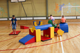 Kinder spielen mit bunten Schaumstoffbausteinen in einer Sporthalle