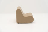 Beige, geschwungene Couch mit minimalistischer Form und glatter Oberfläche