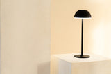Jens Living LED Tischlampe in Schwarz steht auf einem Tisch