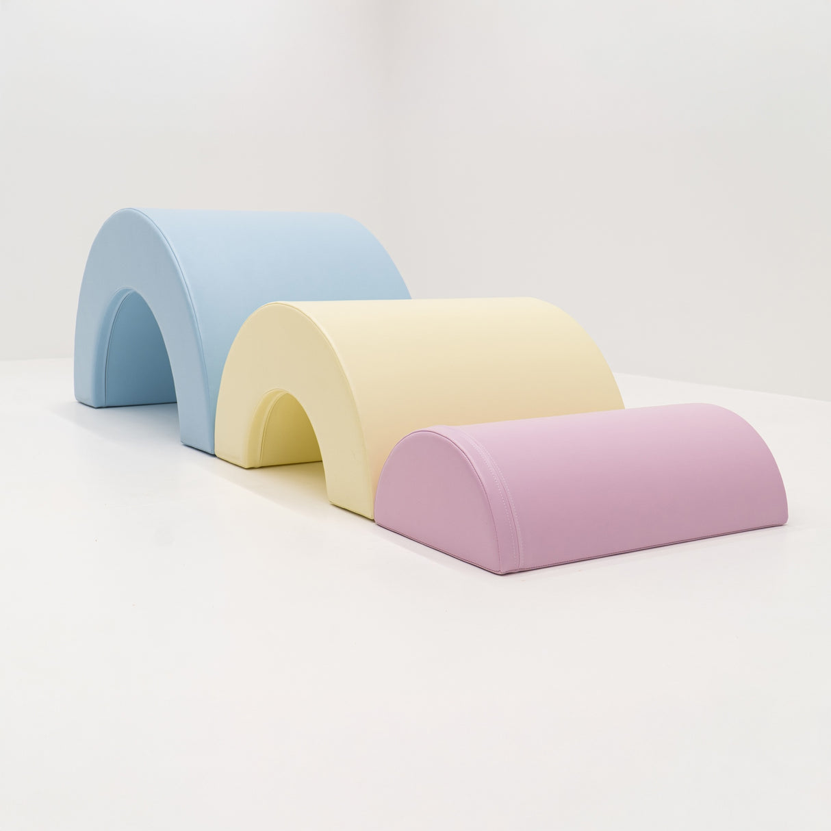 Bunte Schaumstoffbögen in Blau, Gelb und Rosa auf weißem Hintergrund