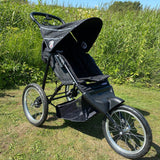 Baby trold Jogger schwarz im Profil auf der Wiese geschlossenen babytrold-jogger-schwarz-profil-wiese-sonnenschutz-geschlossen