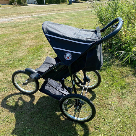 Baby trold Jogger schwarz Seitenansicht von oben auf der Wiese geschlossenen Sonnenschutz