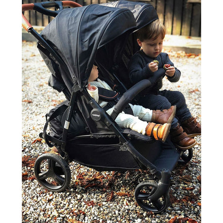 Babytrold Zwillingsuggy schwarz Ansicht im Profil mit zwei Kindern geschlossenen Verdeck