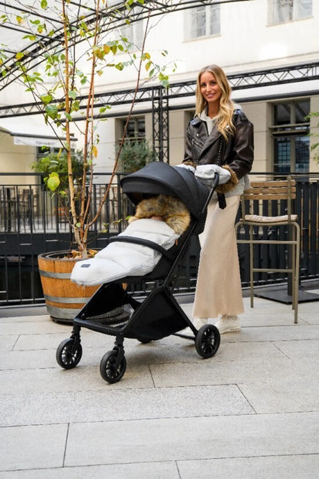Frau mit Kinderwagen in urbaner Umgebung, stilvolles Design und warme Decke