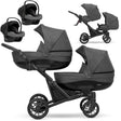 Zwillingskinderwagen-Set, Ansicht bestehend aus zwei 3-in-1 Kinderwagen in Graphit mit schwarzem Rahmen zwei Kinderautositzen.