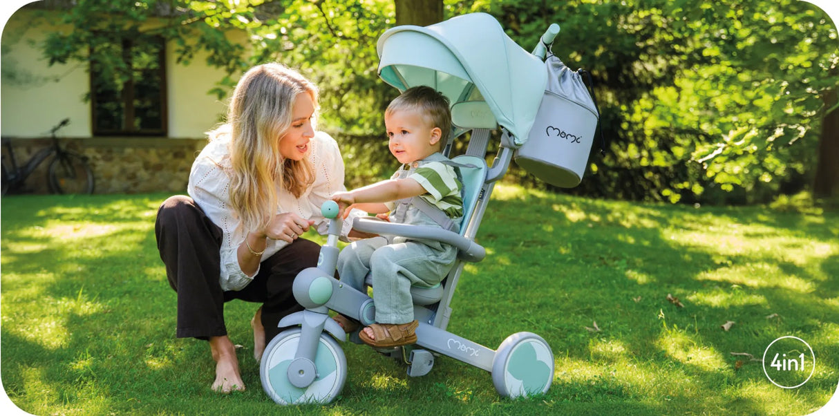 Mutter spielt mit Kleinkind in einem Kinderwagen im Freien