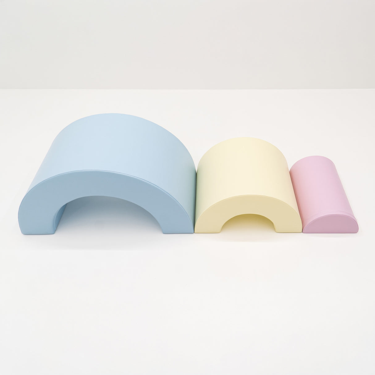 Bunte, geschwungene Holzspielzeuge in Blau, Gelb und Rosa