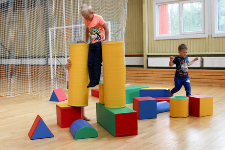 Kinder spielen mit bunten Bauklötzen in einem Innenraum