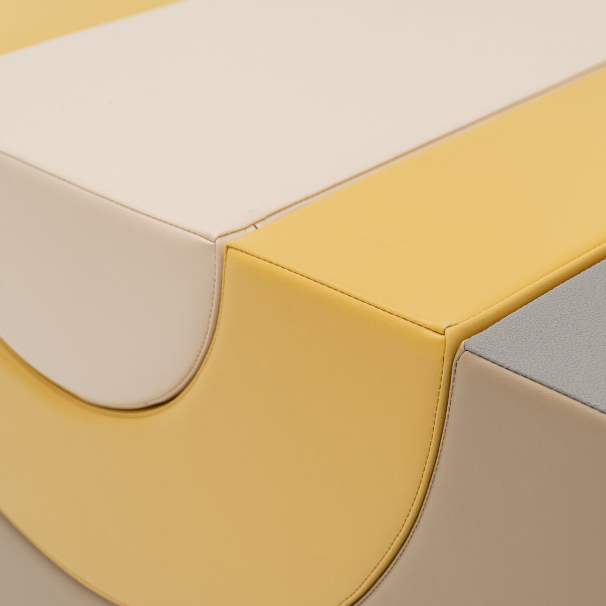 Farbenfrohe Polsterung in Gelb, Beige und Grau mit abgerundeten Kanten