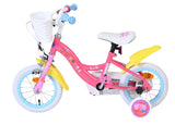 Rosa Kinderfahrrad mit Korb, weißen Reifen und bunten Aufklebern
