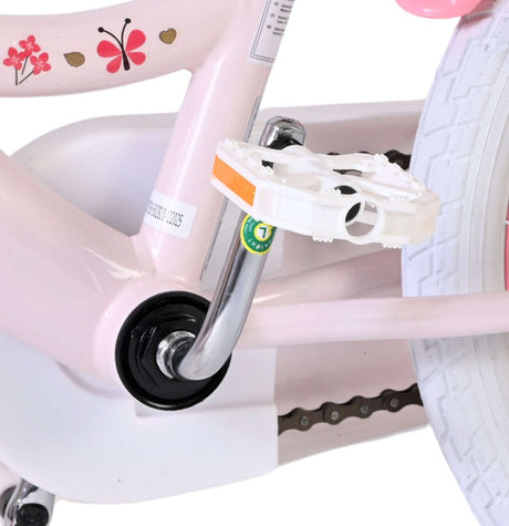 Rosa Kinderfahrrad mit weißen Pedalen und dekorativen Blumenmotiven