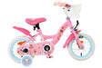 Rosa Kinderfahrrad mit bunten Aufklebern und Korb vorne
