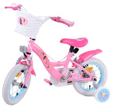 Rosa Kinderfahrrad mit Korb, weißen Reifen und bunten Aufklebern
