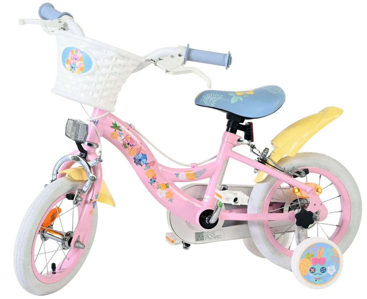 Rosa Kinderfahrrad mit Korb, bunten Aufklebern und Stützrädern