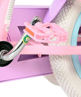 Rosa Fahrradpedal an einem lila Kinderfahrrad mit weißen Reifen
