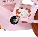 Rosa Kinderfahrrad mit braunen Pedalen und stabiler Rahmenkonstruktion