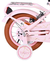 Rosa Fahrrad mit braunem Reifen und Stützrad, dekorative Details sichtbar