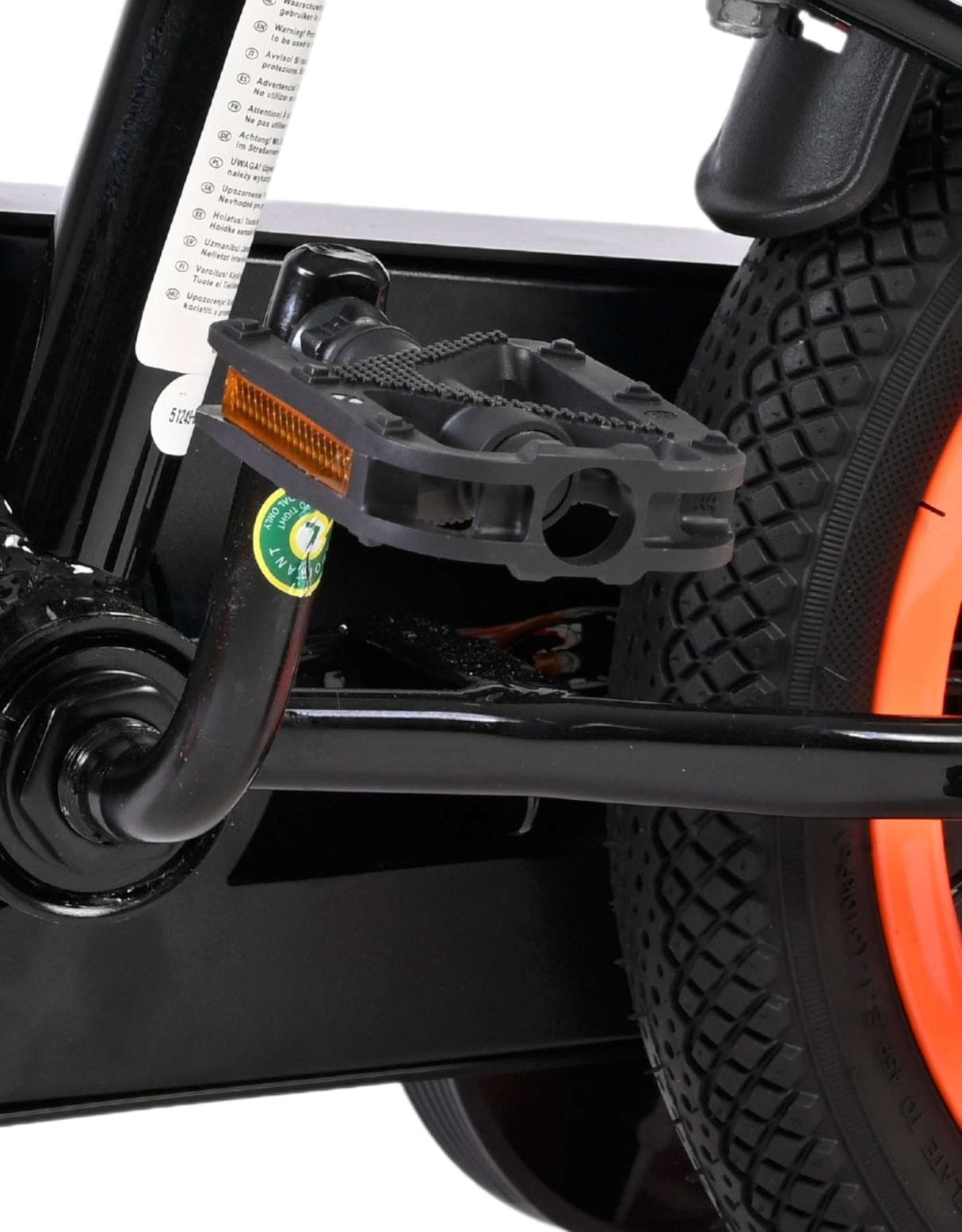 Schwarzes Pedal mit orangefarbenem Reflektor an einem Fahrradrahmen