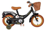 Schwarzes Kinderfahrrad mit Korb, braunen Details und Stützrädern