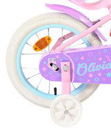 Rosa Kinderfahrrad mit weißen Reifen und bunten Aufklebern