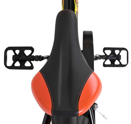 Schwarzer Fahrradsattel mit orangefarbenem Akzent und Pedalen im Hintergrund