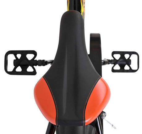 Schwarzer Fahrradsattel mit orangefarbenem Akzent und Pedalen im Hintergrund
