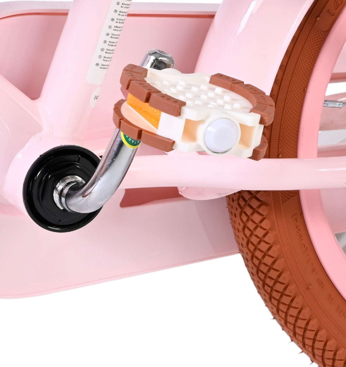 Pedale eines rosa Fahrrads mit braunen Gummieinsätzen und verchromter Achse