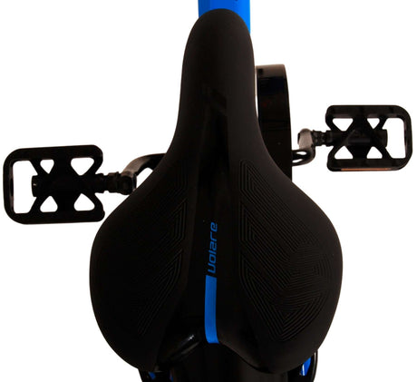 Schwarzer Fahrradsattel mit blauen Akzenten und Pedalen im Hintergrund