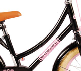 Schwarzes Kinderfahrrad mit pinken Akzenten und braunem Sattel