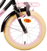 Schwarzes Fahrrad mit pinkem Gepäckträger und breitem, beigem Reifen