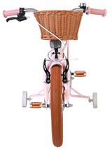Rosa Kinderfahrrad mit Korb und braunen Reifen von vorne betrachtet