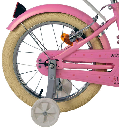 Rosa Fahrrad mit beigem Reifen und Stützrädern, seitliche Ansicht