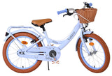 Helles Kinderfahrrad mit Korb, braunen Reifen und bequemen Sattel