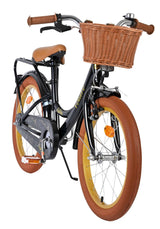 Schwarzes Kinderfahrrad mit Korb, braunen Griffen und orangefarbenen Reifen