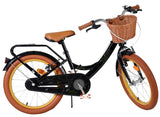 Schwarzes Kinderfahrrad mit Korb, braunen Reifen und gepolsterter Sitzfläche